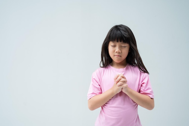 Il bambino sta pregando con le mani giunte in preghiera