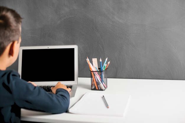 Il bambino studia da remoto a scuola