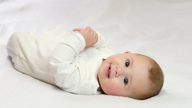 Il bambino su una priorità bassa bianca sta sorridendo. messa a fuoco selettiva Bambino.