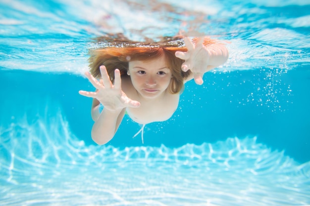 Il bambino subacqueo nuota in piscina bambino sano che nuota e si diverte sott'acqua vacanze per bambini e v