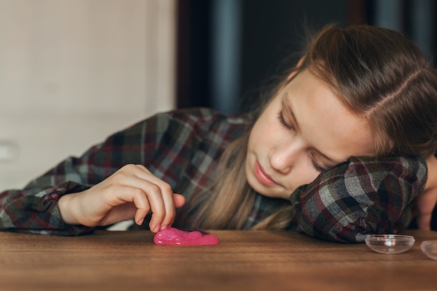 Il bambino tiene in mano un giocattolo chiamato muco, il bambino si diverte e sperimenta.