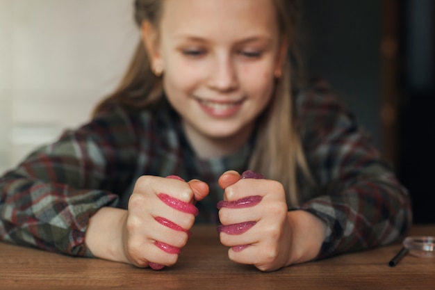 Il bambino tiene in mano un giocattolo chiamato muco, il bambino si diverte e sperimenta.