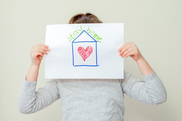 Il bambino tiene in mano una foto di casa