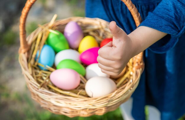 Il bambino tiene le uova di Pasqua nelle sue mani. Messa a fuoco selettiva.