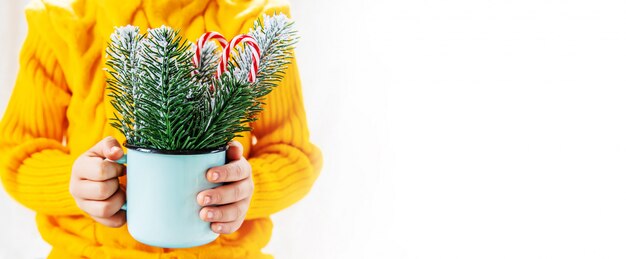 Il bambino tiene una decorazione di Natale e regali su uno sfondo bianco. Messa a fuoco selettiva