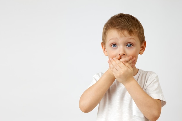 Il bambino trattiene l'emozione della paura coprendosi la bocca con le mani