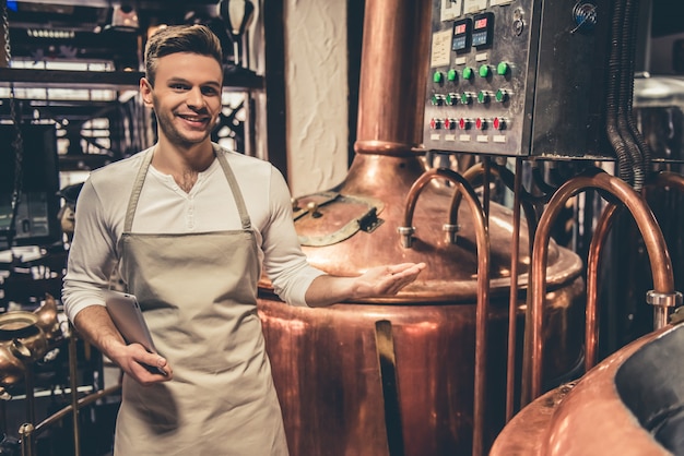 Il barista bello in grembiule sta tenendo una cartella.