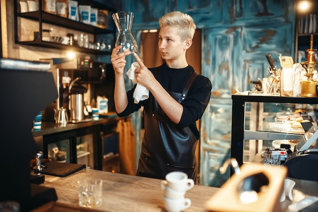 Il barista controlla i piatti puliti dopo aver preparato il caffè