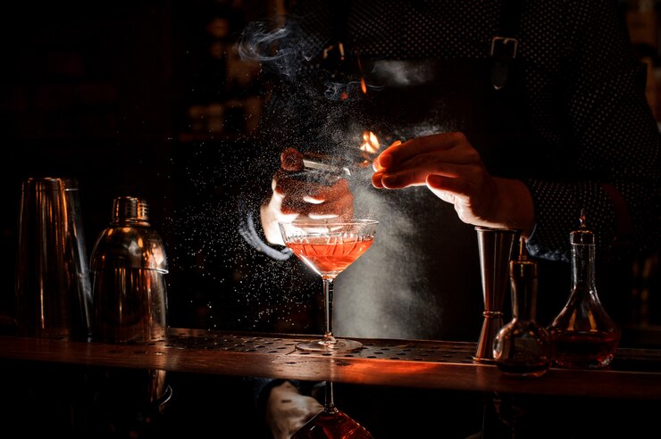 Il barista dà fuoco al dolce cocktail in bocal