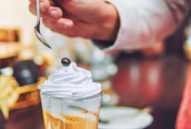 Il barista è decorato di dolci al cioccolato su crema in una tazza di cappuccino.