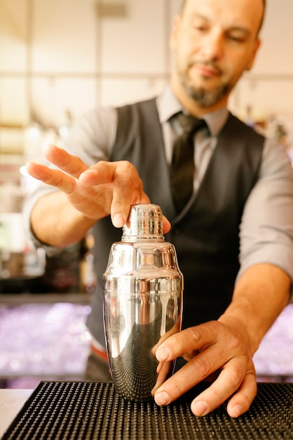 Il barista esperto sta preparando un cocktail al night club