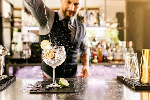 Il barista esperto sta preparando un cocktail al night club