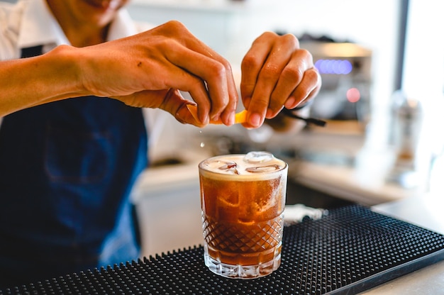 Il barista esperto sta preparando una bevanda alcolica cocktail al night club. Il barista professionista prepara il cocktail