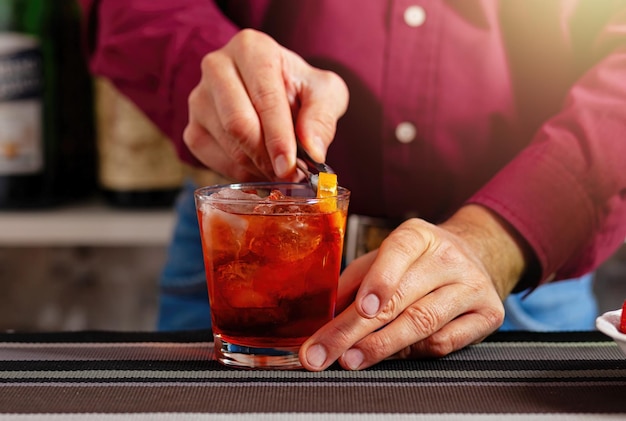 Il barista guarnisce un cocktail al bar.