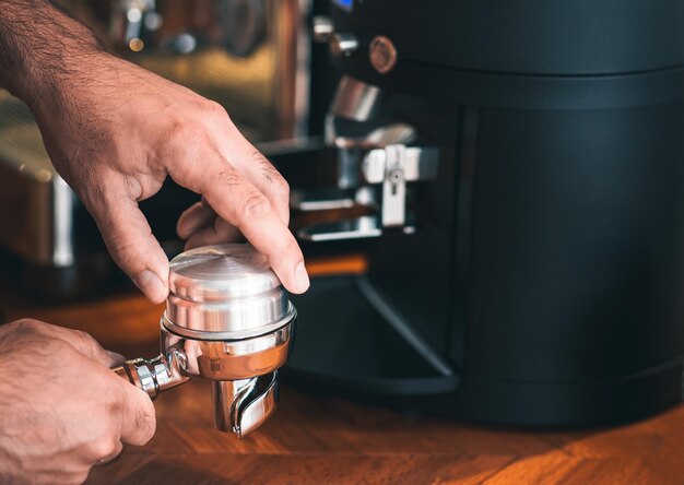 Il barista manomette i chicchi di caffè macinato per preparare l'espresso