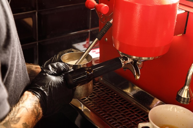 Il barista prepara il caffè alla macchina del caffè nella caffetteria