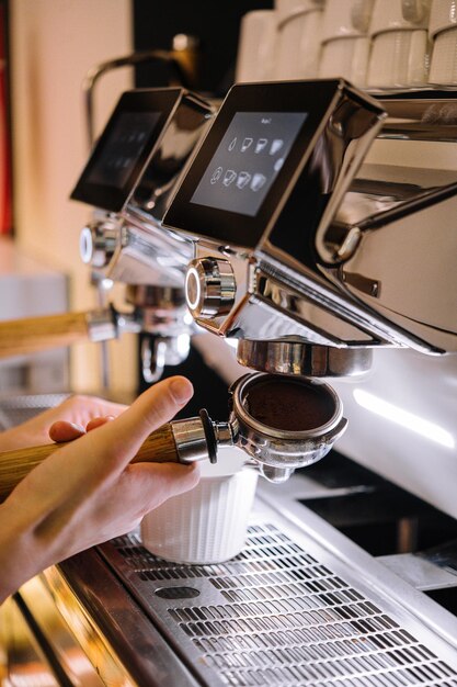 Il barista prepara il caffè nella macchinetta del caffè