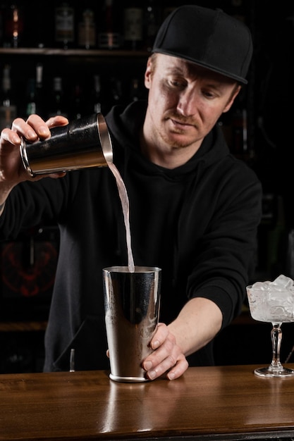 Il barista prepara il classico cocktail alcolico del club Clover al bar Il barista mescola il vermouth secco al limone bianco d'uovo e il gin per preparare il cocktail del club Clover