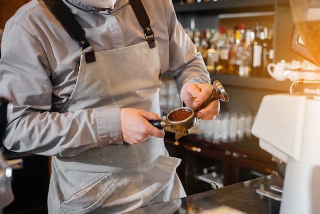 Il barista prepara un delizioso caffè in un moderno primo piano della caffetteria.