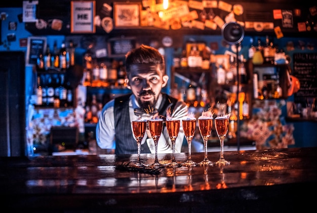 Il barista professionista mostra il processo di preparazione di un cocktail dietro il bar