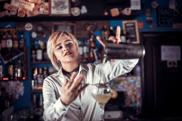 Il barista professionista sorprende con i suoi visitatori del bar di abilità al bancone del bar