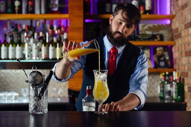 Il barista serve un cocktail per il cliente al bar