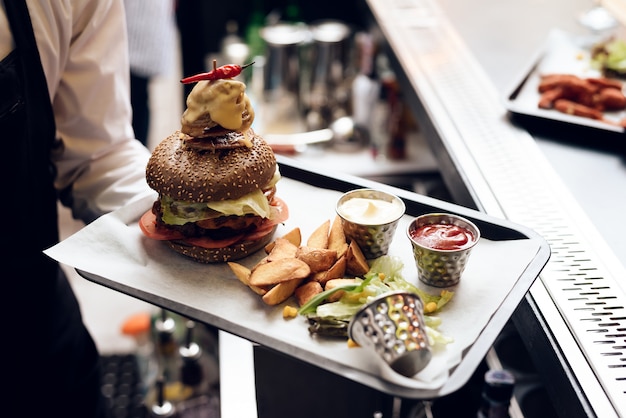 Il barista serve un hamburger per le persone.