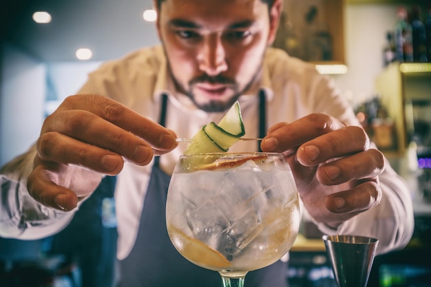 Il barista sta decorando un cocktail