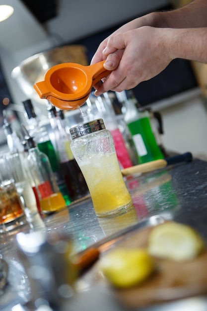 Il barista sta filtrando il cocktail in un bicchiere