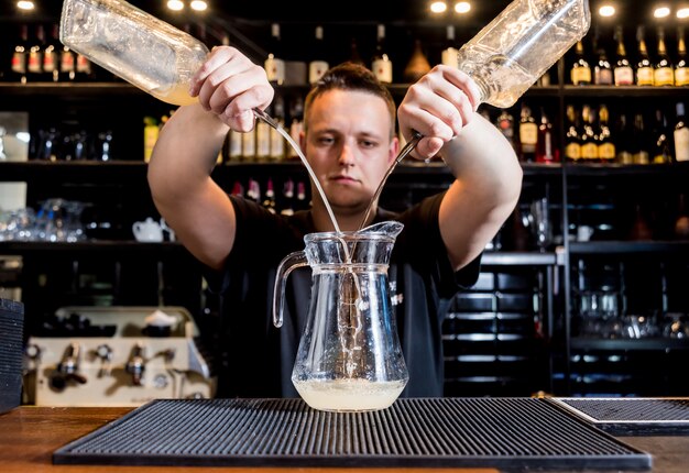 Il barista sta preparando un cocktail al bancone del bar. Cocktail freschi. barista