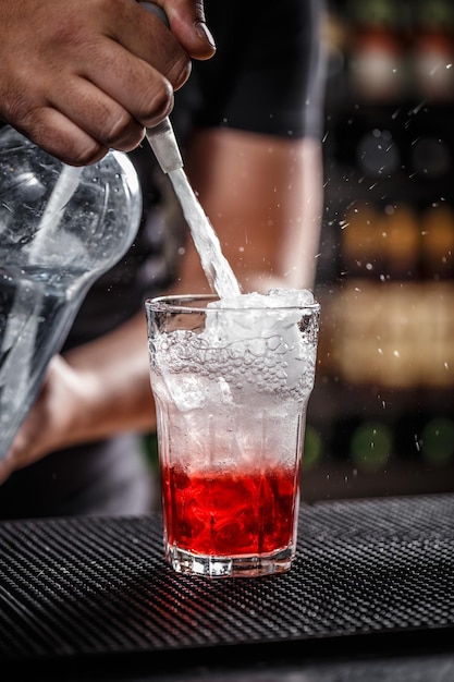 Il barista sta versando acqua gassata