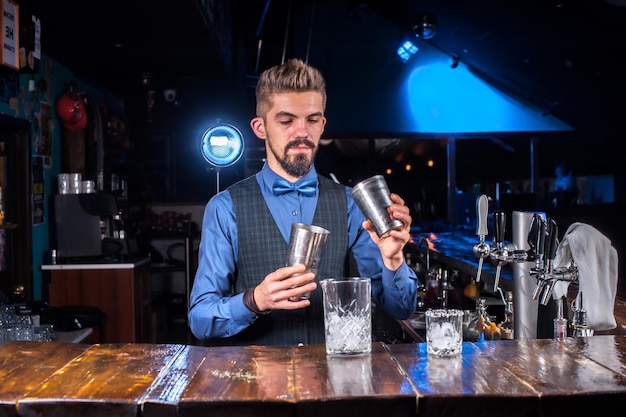 Il barman esperto sorprende con i suoi visitatori esperti del bar al bancone del bar