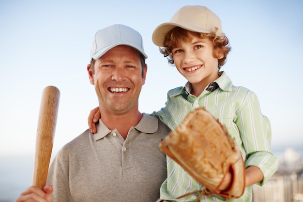 Il baseball corre in famiglia Ritratto ritagliato di un uomo maturo che trasporta il suo giovane figlio mentre gioca a baseball