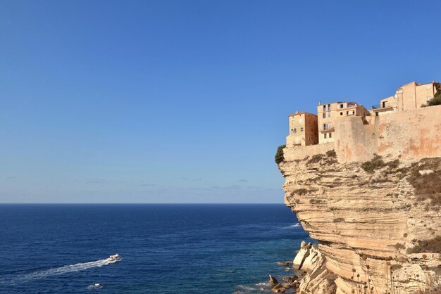 Il bastione sopra la scogliera calcarea di Bonifacio in Corsica si affaccia sul mare in un cielo azzurro