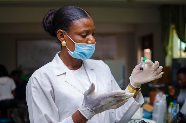 Il bellissimo medico africano guarda il vaccino alla sua mano