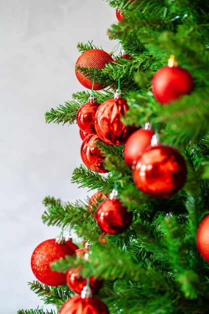 Il bello albero di Natale con le bagattelle rosse si chiude su