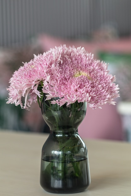 Il bello crisantemo rosa vago fiorisce il mazzo in vaso di vetro sulla tavola.