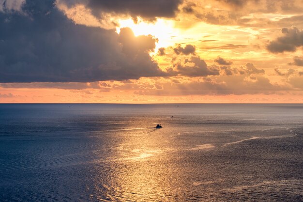 Il bello mare dorato con luce solare splende al tramonto