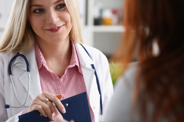 Il bello medico femminile sorridente della medicina spiega