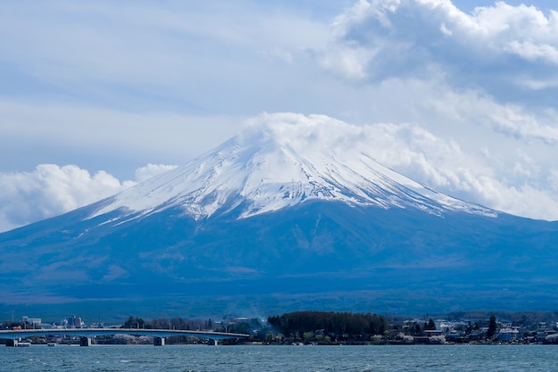 Il bello monte Fuji con neve ha ricoperto e cielo blu nel lago Kawaguchiko