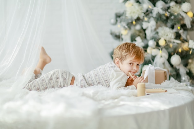 Il bello piccolo neonato in pigiama con le stelle celebra il Natale.