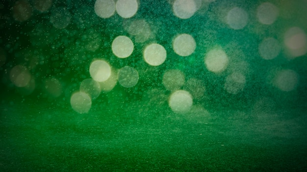 Il bokeh sfocato di colore verde illumina lo sfondo - carta da parati orizzontale, poster. Scatto elegante, festoso ed elegante. Colori alla moda. Illuminato, luci, effetti glitter. Decorazione celebrativa.