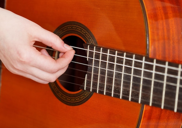 Il braccio femminile suona sulla chitarra acustica