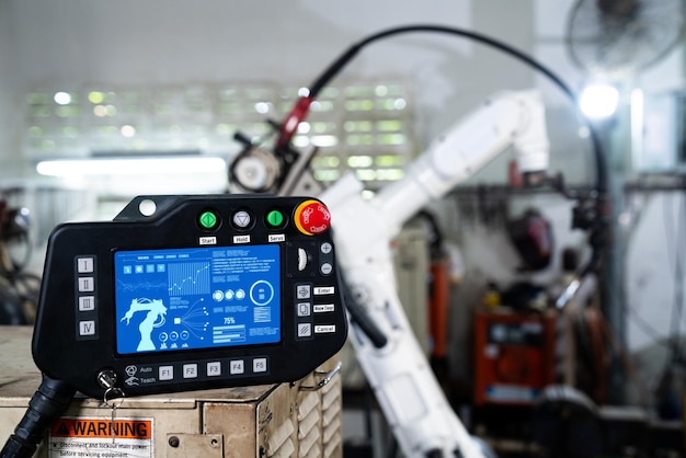 Il braccio robotico e il suo pannello di controllori esperti in un'officina di fabbrica