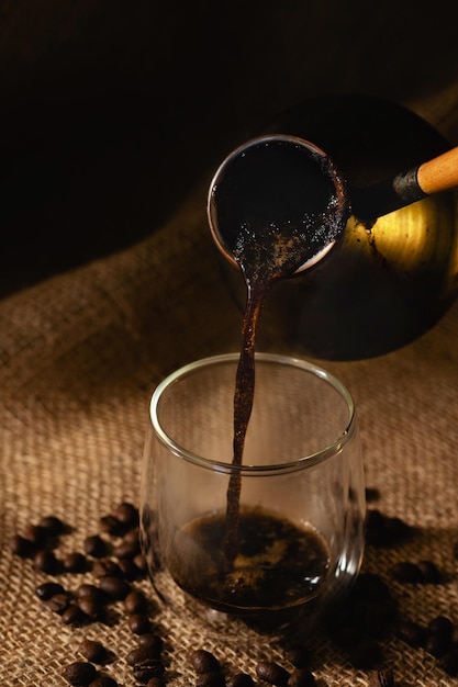 Il caffè appena preparato viene versato in una tazza di caffè trasparente