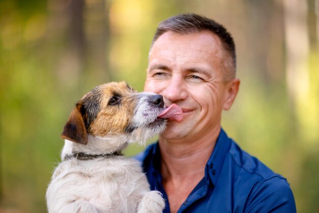 Il cagnolino lecca la faccia di un uomo