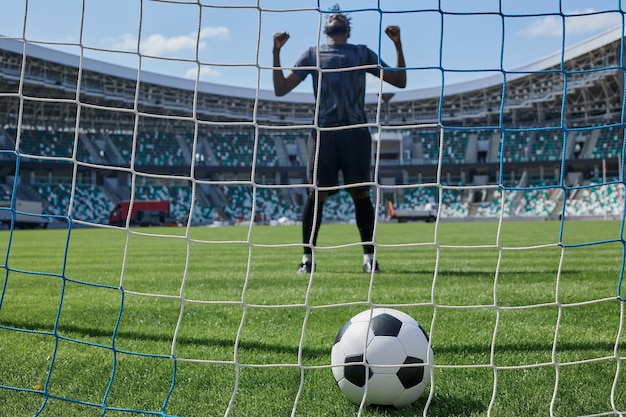 Il calciatore calcia la palla in porta allo stadio