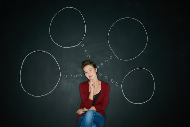 Il cambiamento avviene quando decidi di realizzare una ripresa in studio di una giovane donna in posa con un'illustrazione in gesso di bolle di pensiero su uno sfondo scuro