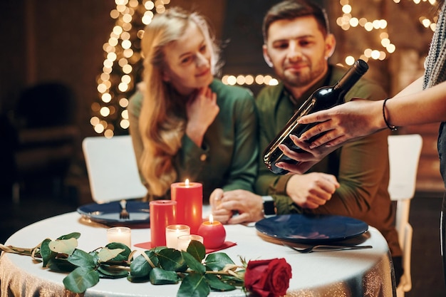 Il cameriere attende il pagamento La giovane coppia adorabile ha una cena romantica insieme al chiuso