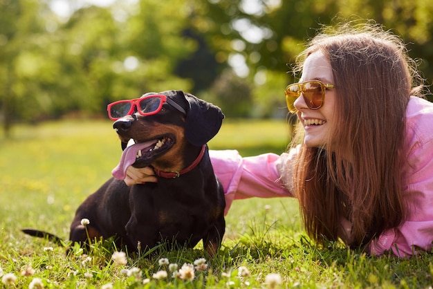 il cane bassotto in occhiali da sole con la ragazza si gode la giornata di sole